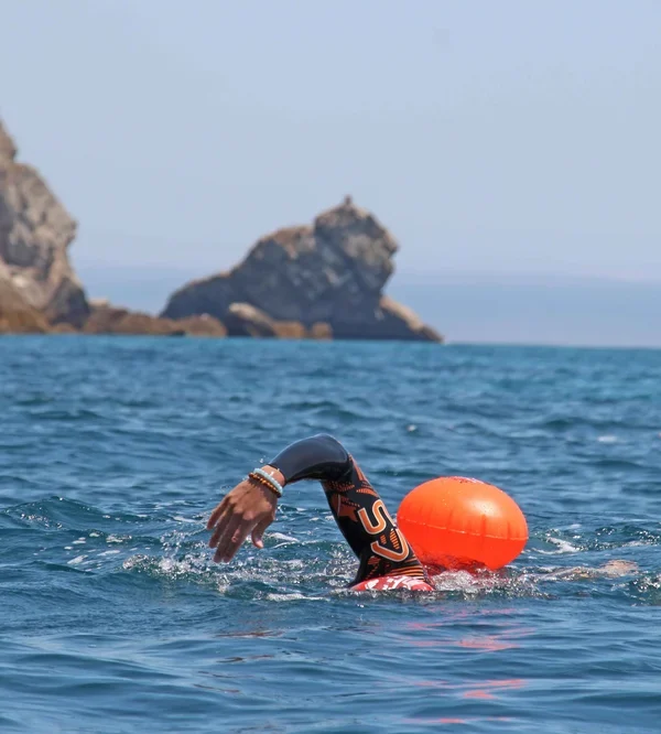 Swimmer wearing an orca wetsuit and a SwimSecure buoy training on the coast of Sesimbra to cross the