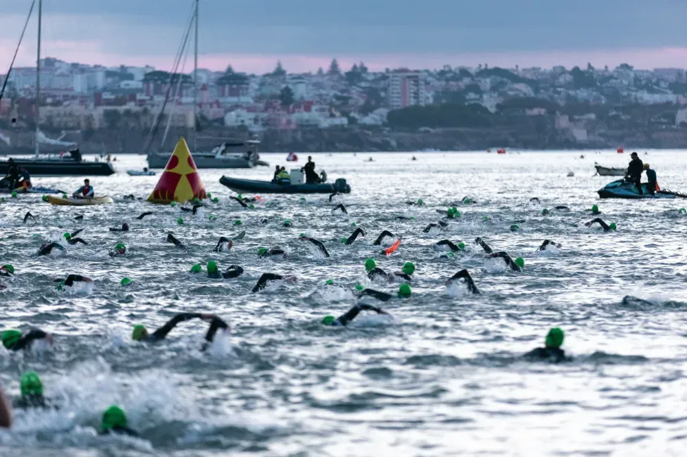 Swimmers at the IRONMAN Portugal Cascais 2026 swim start at sunrise